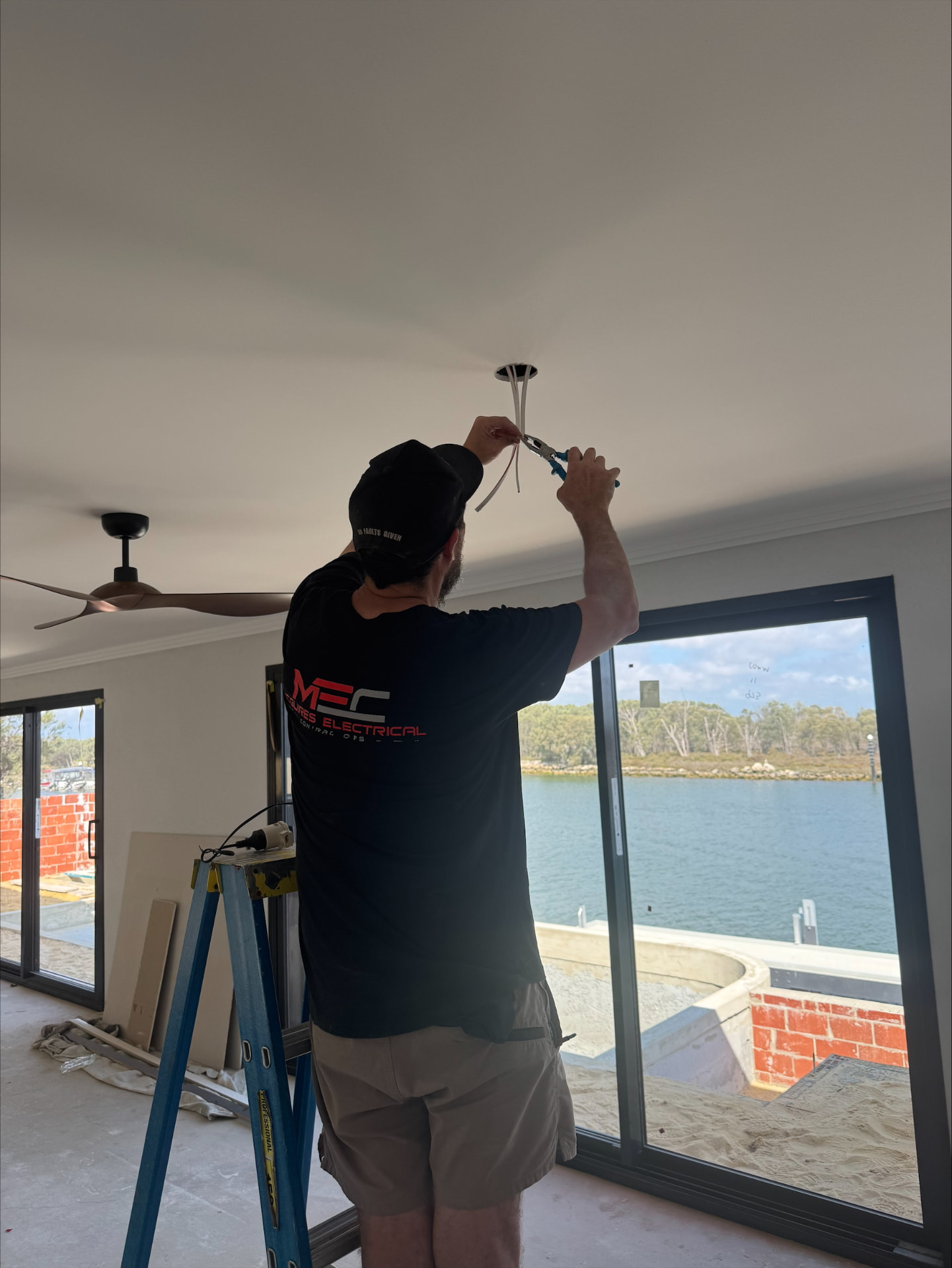 McGuires electrician installing a recessed downlight in a Perth home